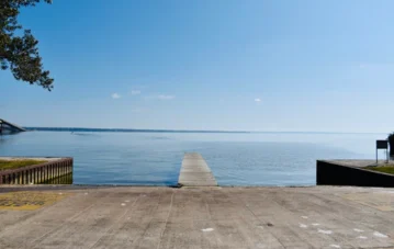 Wooden dock leading to calm blue water.